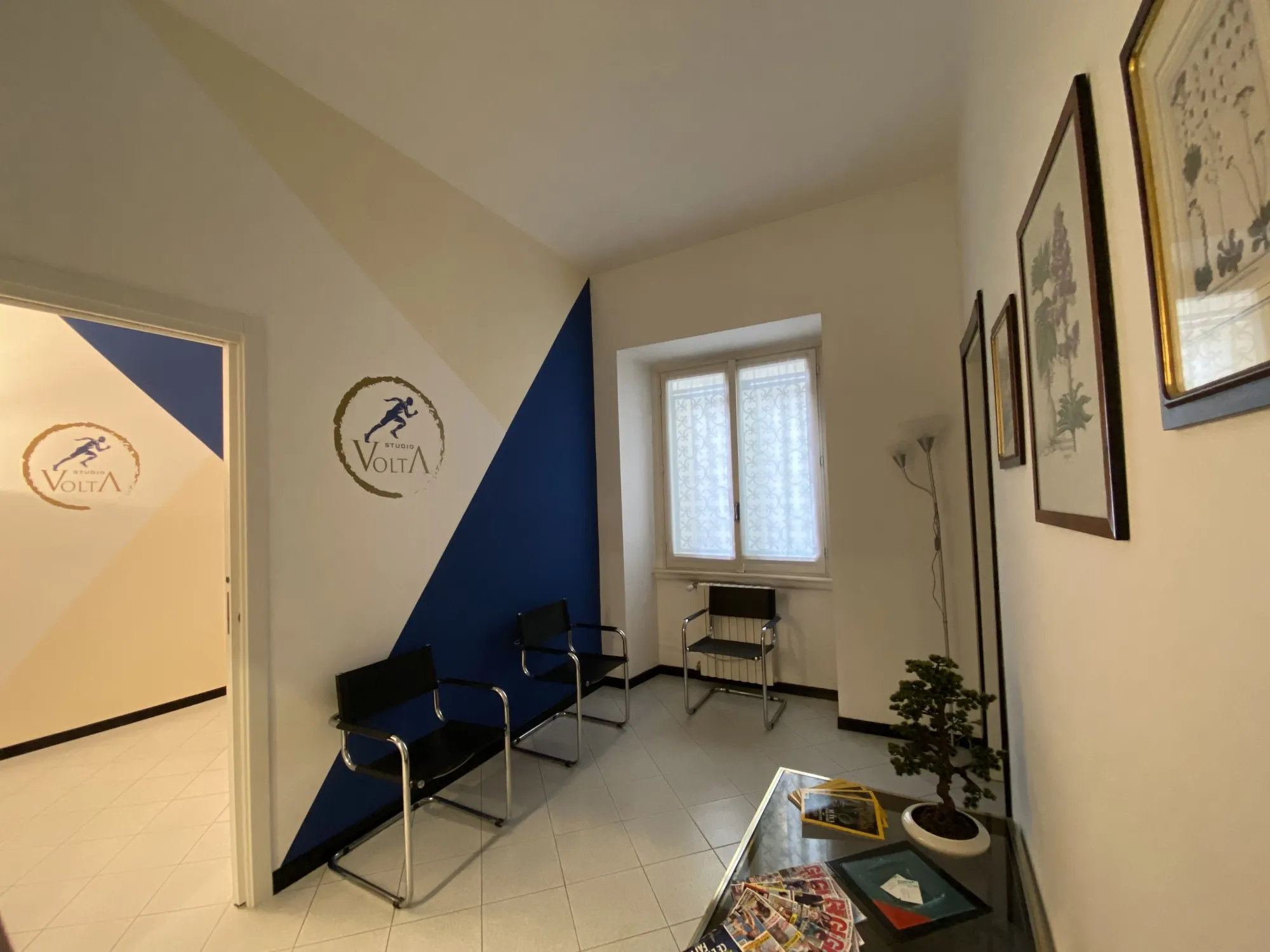 La sala d’attesa di Studio Volta, con la parete blu e il logo